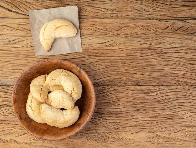 Bollo de queso típico sudamericano de chipas sobre mesa de madera con espacio para copiar