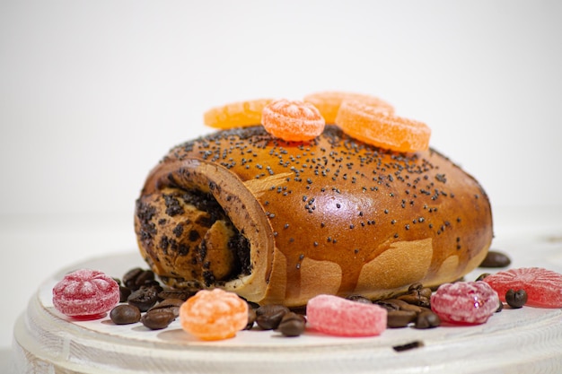 Bollo con semillas de amapola y bayas sobre un fondo claro Sobre un corte de madera Apetitoso desayuno o merienda