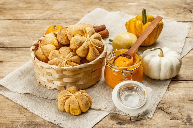 Bollos de calabaza o galletas, productos horneados tradicionales de otoño. Comida casera de temporada y decoración otoñal. Fondo de tablas de madera vieja, cerrar