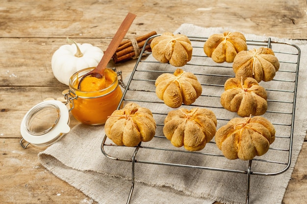 Bollos de calabaza o galletas, productos horneados tradicionales de otoño. Comida casera de temporada y decoración otoñal. Fondo de tablas de madera vieja, espacio de copia