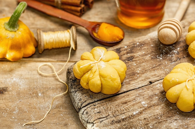 Bollos de calabaza o galletas, productos horneados tradicionales de otoño. Ingredientes de temporada para cocinar comida casera. Fondo de tablas de madera vieja, cerrar