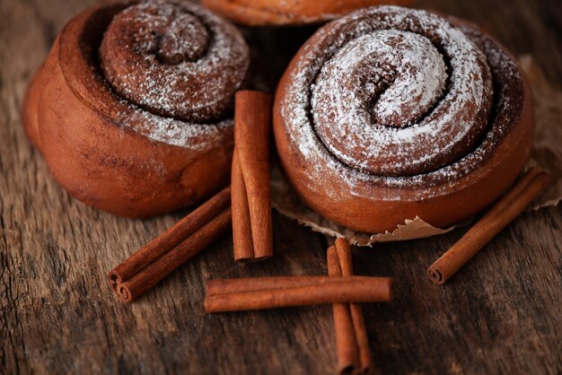 Bollos de canela frescos sobre fondo de madera