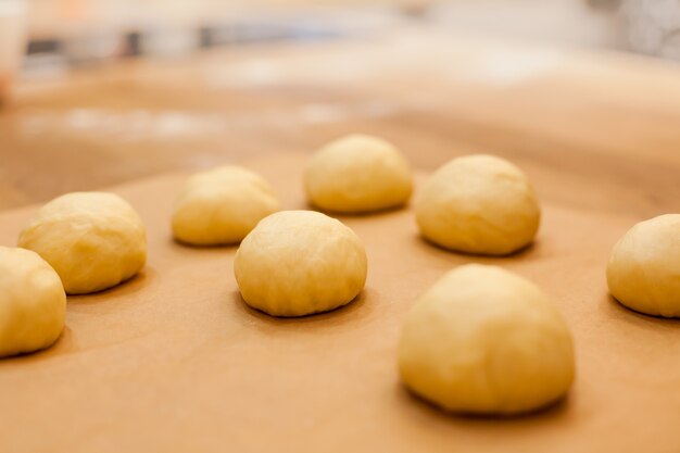 Bollos caseros crudos en la mesa de la cocina en la fabricación