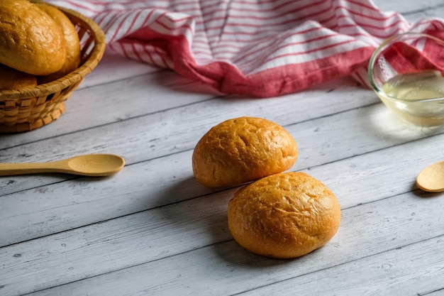 bollos en una cesta de mimbre sobre un fondo de madera blanca, con espacio para copiar, deliciosos bollos caseros