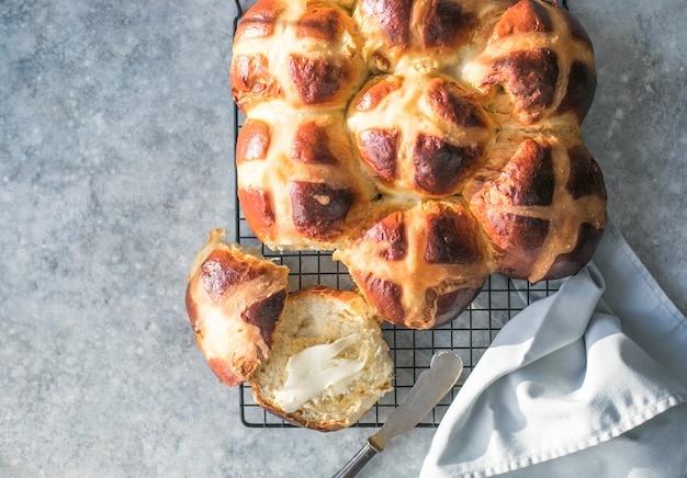 Bollos cruzados calientes con mantequilla. Dulce tradicional de pascua