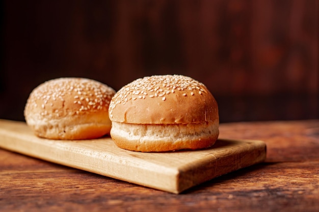 Bollos de hamburguesa Semillas de sésamo en la parte superior Fondo de madera Concepto de comida