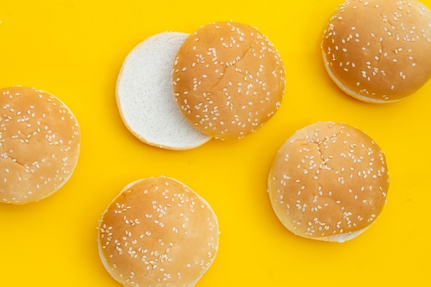 Bollos de hamburguesa con sésamo sobre fondo amarillo