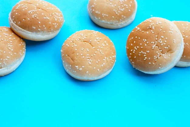 Bollos de hamburguesa con sésamo sobre fondo azul.