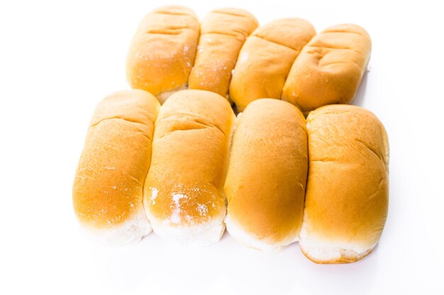 Bollos de hot dog recién horneados sobre un fondo blanco.