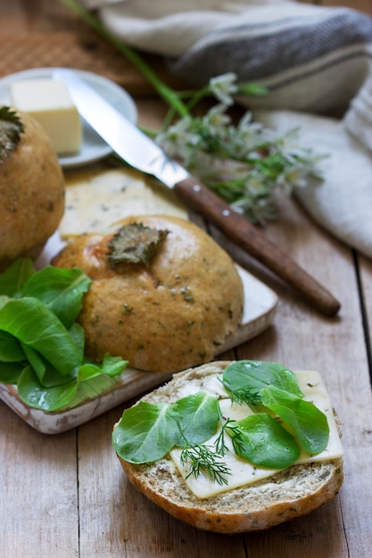 Bollos de ortiga servidos con mantequilla, queso y verduras. Estilo rústico