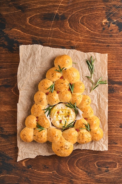 Bollos de pan Árbol de Navidad con queso camembert asado y romero sobre fondo rústico Recetas navideñas Menú de Navidad Pasteles de Navidad o Navidad Vista superior Espacio de copia