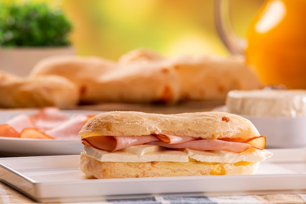 Bollos de queso brasileño con queso y jamón. Café de mesa por la mañana con pan de queso.