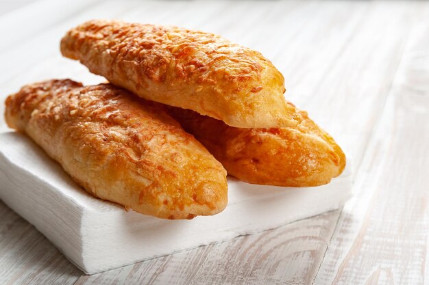 Bollos de queso, pan con queso sobre un fondo blanco de madera