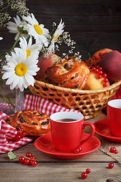 Bollos recién horneados con una taza de café en madera rústica