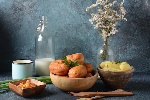 Bollos rellenos de leche Pirozhki con cebollas verdes, agáricos de miel en escabeche, champiñones y patatas