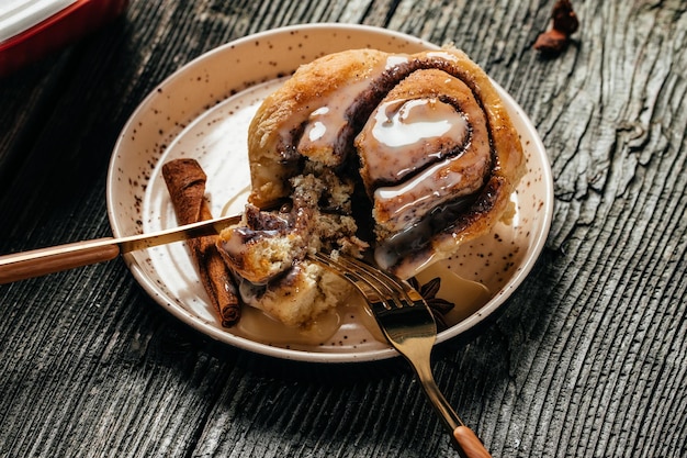 Bollos Sinnabon caseros con canela y salsa de crema blanca bollos de postre tradicionales dulces