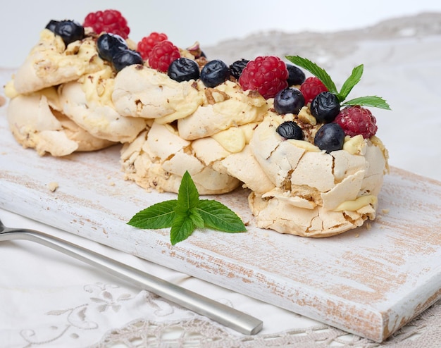 Bolo assado feito de proteína de frango batido e creme decorado com frutas frescas Sobremesa Pavlova