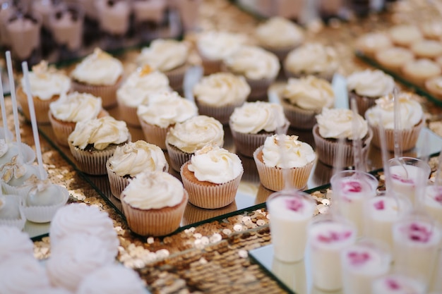 Bolo bar no casamento diferentes tipos de doces na mesa bolo éclair pops muffins e outros