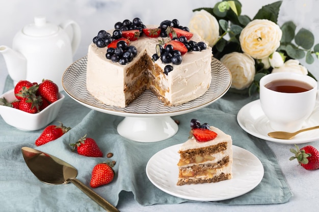 Bolo branco com uma coroa de frutas no fundo branco