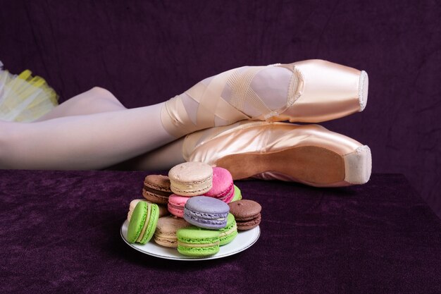 Foto bolo brilhante na mesa e pés de bailarina em sapatos de ponta em close-up