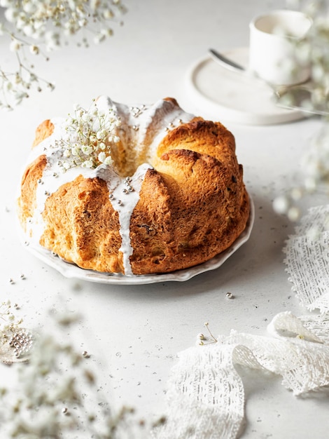 Bolo bundt com flores granuladas em chave alta com um quadro de flores em desfoque em primeiro plano