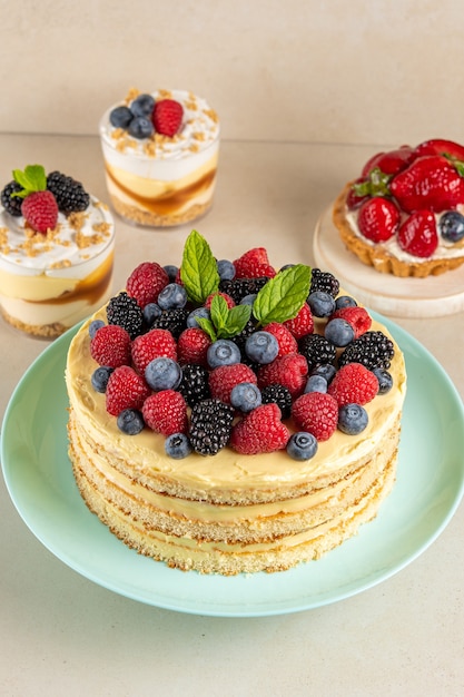 Bolo caseiro com frutas frescas e sobremesas doces na mesa.