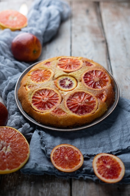 Bolo caseiro com laranjas de sangue na mesa de madeira