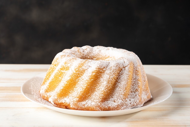 Bolo caseiro de baunilha em fundo branco de madeira