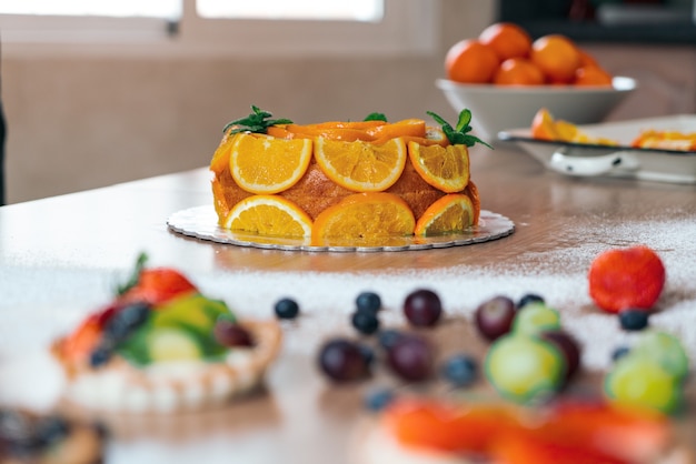 Bolo caseiro de laranja com laranjas fatiadas em uma cozinha