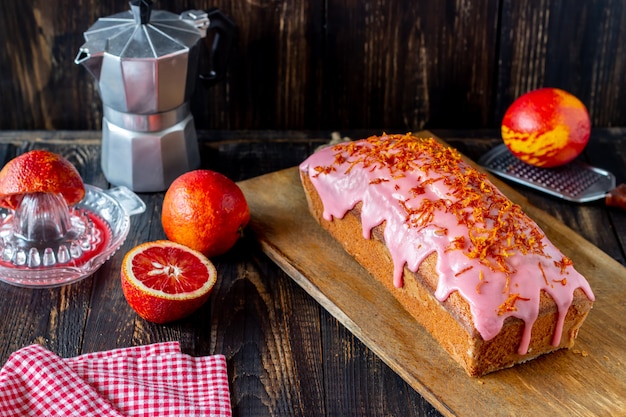 Bolo caseiro de laranja em uma mesa de madeira. Laranjas vermelhas. Receitas. Pastelaria.