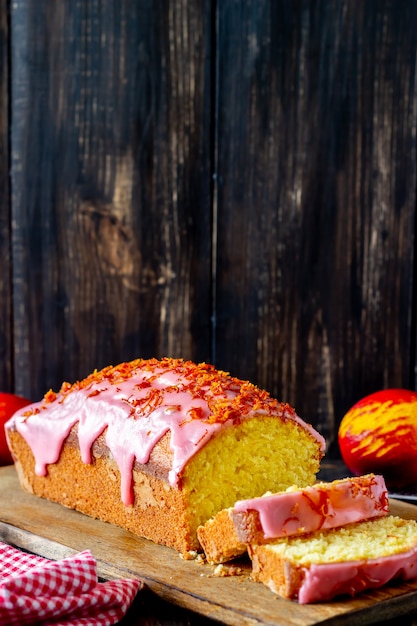 Bolo caseiro de laranja em uma mesa de madeira. Laranjas vermelhas. Receitas. Pastelaria.