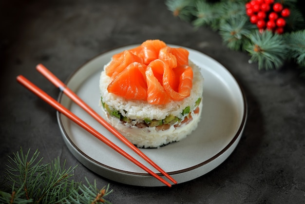 Bolo caseiro de sushi com salmão levemente salgado, abacate, queijo de pasta mole e algas marinhas. Superfície de Natal.