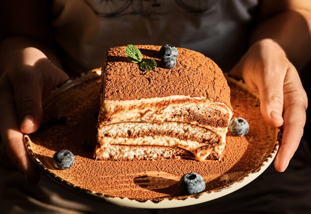 Bolo caseiro de tiramisu decorado com folhas de hortelã e mirtilos