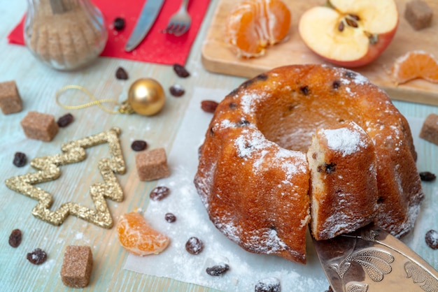 Bolo caseiro delicioso cozido fresco com tangerinas, passas. Decorações de Natal.