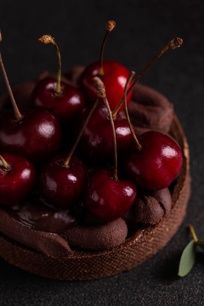 Bolo com cereja e creme de chocolate em uma placa preta