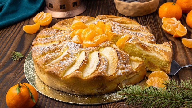 Bolo com tangerina e tangerinas em fundo de madeira rústico