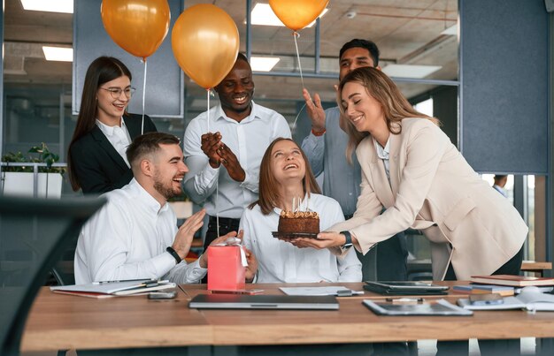 Foto bolo com velas funcionário com aniversário no grupo de trabalhadores do escritório