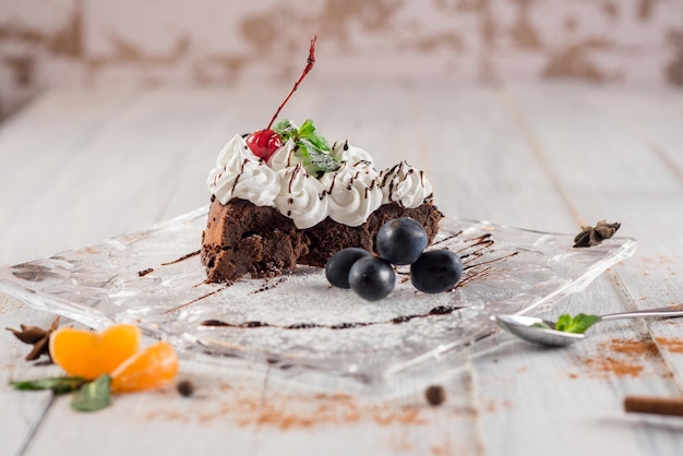 Bolo cremoso doce com frutas no fundo branco de madeira