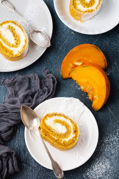 Bolo de abóbora de sobremesa com creme de manteiga e laranja em concreto azul escuro