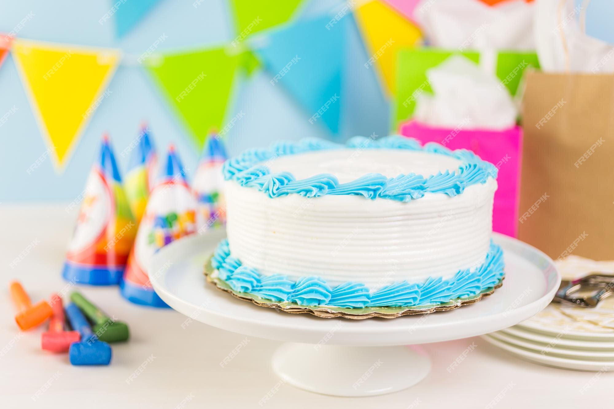 Bolo de aniversário branco simples com glacê branco e azul.