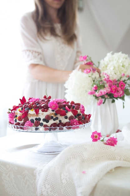 Bolo de aniversário colorido com flores de baga em um fundo branco com espaço de cópia