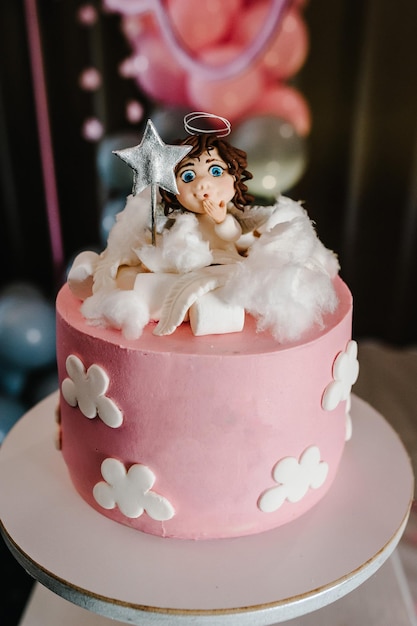 Foto bolo de aniversário com anjo em uma decoração de festa de balões de fundo copiar espaço conceito de celebração bolo na moda barra de doces mesa com sobremesa de doces doces