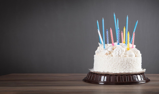 Bolo de aniversário com velas coloridas acesas