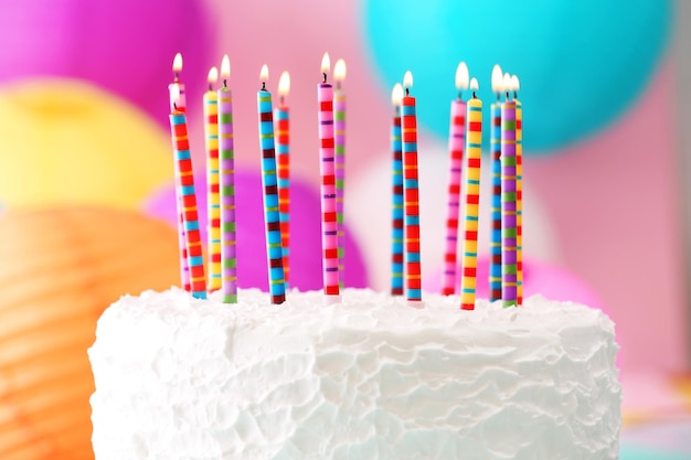 Foto bolo de aniversário com velas em fundo colorido