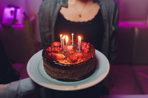 Bolo de aniversário com velas, luzes brilhantes bokeh.