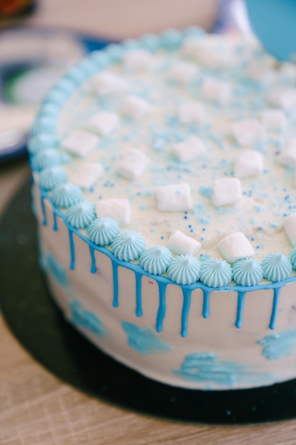 Foto bolo de aniversário decorado com pequenos marshmallows e flores creme