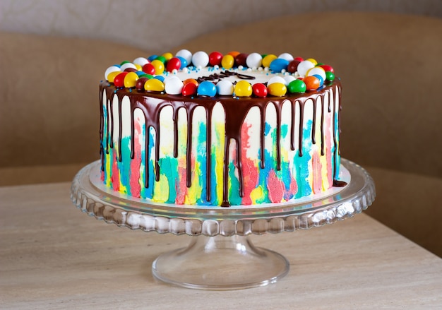 Foto bolo de aniversário infantil com pinceladas brilhantes de creme e chocolate na mesa