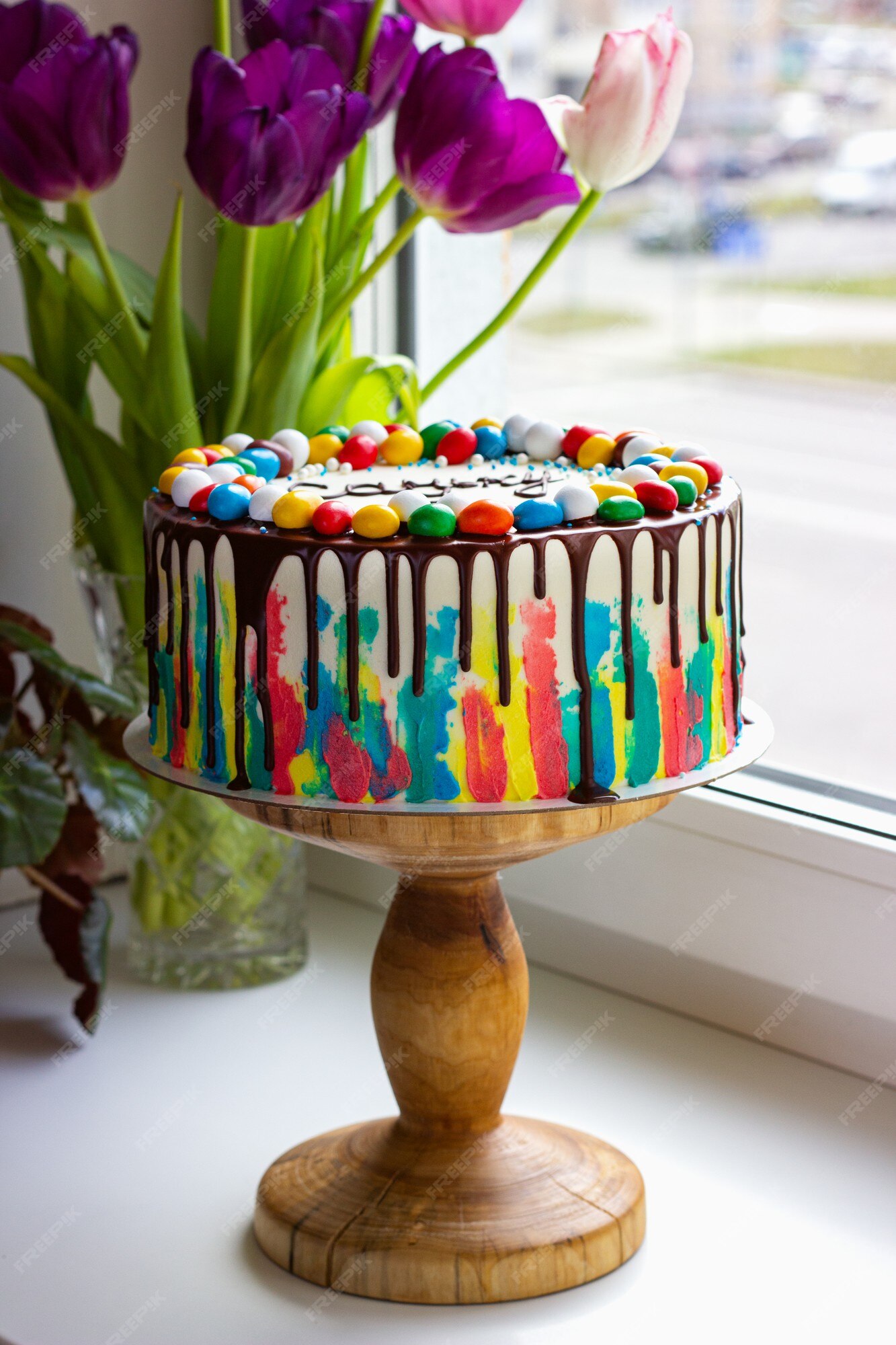 Bolo de aniversário infantil com pinceladas brilhantes de creme e chocolate  na mesa