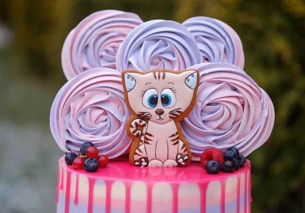 Bolo de aniversário lindo com a figura de um gatinho e merengue brilhante em um verde