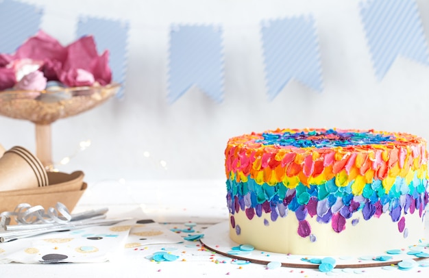 Bolo de aniversário multicolorido decorado com creme. Conceito de festa de aniversário.